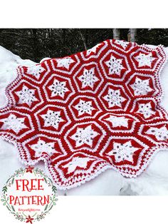 a red and white crocheted afghan with snowflakes on it in the snow