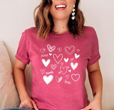 Lots of Hearts valentines day shirt, glitter, love text, mama shirt, family matching, personalized gift, love, hearts, v-day, pink and red ----WASHING INSTRUCTIONS----- - Please turn the tee inside out before washing - Cold machine wash in gentle cycle - Do not bleach - Do not dry clean - Do not iron over the HTV Cute Heart Print Tops For Valentine's Day, Pink Heart-shaped Top For Valentine's Day, Valentine's Day Heart Print Tops, Pink Short Sleeve Top For Valentine's Day, Cute Heart Print T-shirt For Valentine's Day, Personalized Short Sleeve T-shirt For Valentine's Day, Personalized Short Sleeve Tops For Valentine's Day, Pink Heart Print T-shirt For Valentine's Day, Pink Valentine's Day Graphic Tee