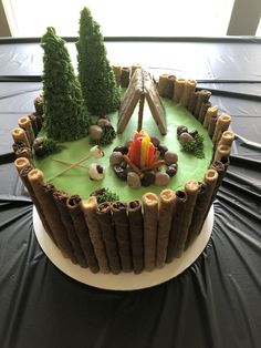 a cake decorated with trees and logs on a table