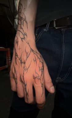 a man's hand with tattoos on it and his left hand in the middle