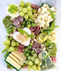 a large platter of cheeses, meats and vegetables