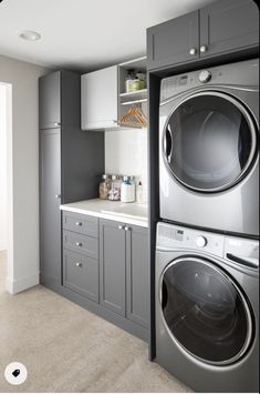 a washer and dryer in a room with gray cabinets on either side of the door