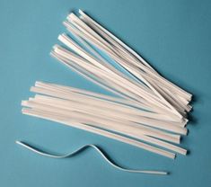 several white plastic straws on a blue surface with one string attached to the end