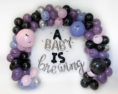 a baby is brewing sign surrounded by balloons