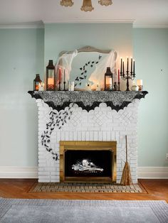 a white fireplace with candles and decorations on top