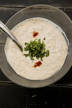 a glass bowl filled with white sauce and garnish