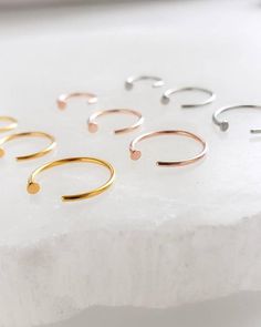 Tiny Dot Hug Hoop Nose Ring. • T H E • D E T A I L S • • Available in Surgical steel, Gold plated surgical steel or Rose gold plated surgical steel • Hoop wire measures 20g • Three sizes: 6mm, 8mm or 10mm• Thoughtfully packaged & ready for gift giving!• Handmade, just for you, in our sunny California Studio• Our 365 Guarantee: Our jewelry is guaranteed for 1 year after purchase date against defects.• Your item is carefully wrapped in non-tarnish tissue & placed in our signature "Studio Blue" sat Nose Ring Jewelry, Modern Hoop Earrings, Tiny Hoop Earrings, Sunny California, Dainty Studs, Nose Rings Hoop, Tiny Studs, Studio Blue, Delicate Earrings