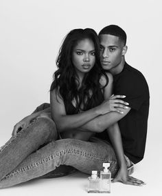 a man and woman sitting next to each other with perfume bottles in front of them