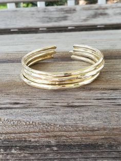 "We love our lightly hammered bangles. So, we've added a new love with our triple, heavily hammered bangles. Our first round of hammering is on the anvil, where we burn some negative energy banging away at each bangle. Our second round is on the bracelet mandrel, where we shape and add layered textures. Our final hammering is back on the anvil where we add the last dents and divets to create a stunning look that you are sure to love. Create your own set by choosing your size and number of bangle Adjustable Hoop Bangle For Everyday, Adjustable Stackable Bands As Gift, Adjustable Stackable Round Bracelets, Adjustable Open Band Bracelet As Gift, Adjustable Open Band Bracelet For Gift, Stackable Bracelets For Gift, Adjustable Stackable Bangle For Everyday, Adjustable Hammered Everyday Bracelets, Handmade Adjustable Hoop Bracelets