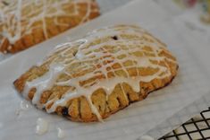 two cookies with icing sitting on top of each other next to a cooling rack