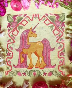 an embroidered unicorn with pink flowers surrounding it