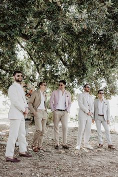 a group of men standing next to each other under a tree