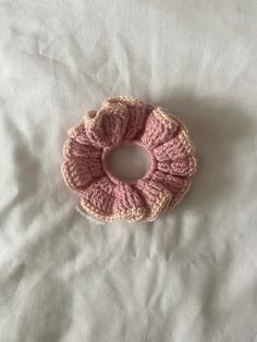 a pink crocheted scrunch on a white sheet