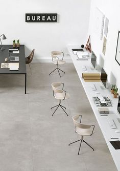 an office with several desks and chairs on each side of the wall, along with a sign that reads bureau