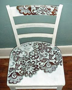 a white chair with flowers painted on it and the words pretty up an old chair spray paint through lace