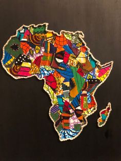 an african map made out of stickers on a black surface with the shape of africa highlighted in multicolored images