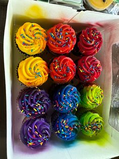 a box filled with lots of colorful cupcakes