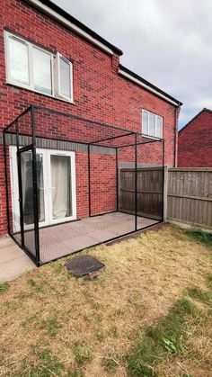 an enclosed patio in front of a red brick house