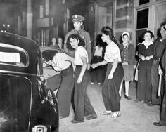 an old black and white photo of some people in front of a police car with the door open