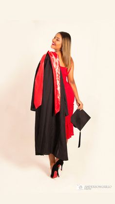 a woman wearing a graduation gown and holding a black hat with red tassels