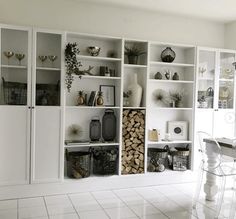 a room filled with lots of white shelves covered in vases and other items on top of them