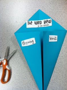 a pair of scissors sitting on top of a table next to an origami