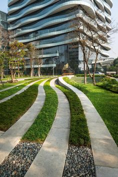 a modern building with grass and rocks in front