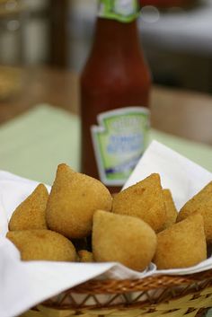 a basket filled with tater tots next to a bottle of ketchup