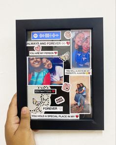 a person holding up a framed photo with pictures and words on the front, along with other stickers