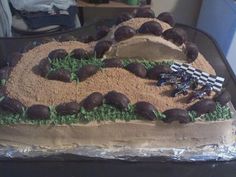 a cake made to look like a dirt track with rocks and grass in the middle