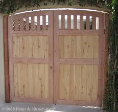 two wooden gates are open in front of a house with ivy growing on the fence