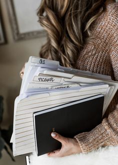 a woman holding several files in her hands