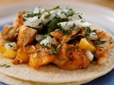 a tortilla topped with chicken and pineapple salsa