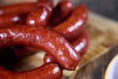 two sausages sitting on top of a wooden cutting board