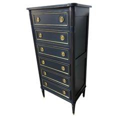 a black and gold chest of drawers with brass knobs on the top, against a white background