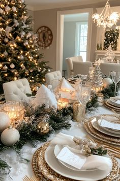 a dining room table set for christmas with white and gold plates, silverware and candles