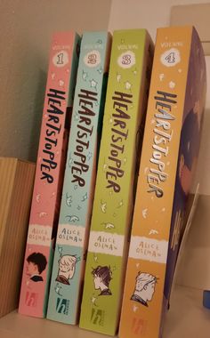 four children's books are lined up on the shelf next to each other,