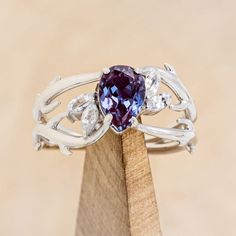 a close up of a ring on top of a piece of wood with an amethorate