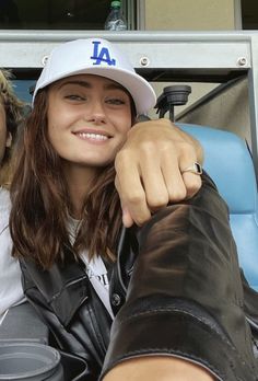 a woman sitting in the bleachers with her arm around someone's shoulder