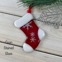 a red and white christmas stocking ornament hanging from a tree