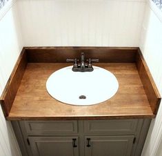 a white sink sitting on top of a wooden counter