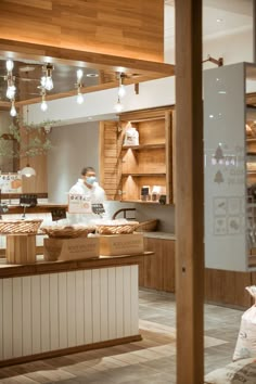 a man is working behind the counter at a bakery