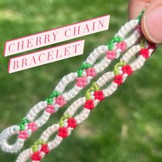 a hand holding a piece of yarn with the words cherry chain bracelet on it