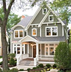 a gray house with white trim on the front porch and steps leading up to it