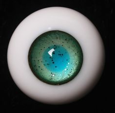 a close up of a white and green object with blue inside the center on a black background