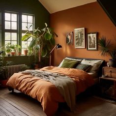 a bedroom with orange walls and green plants on the wall, along with a bed