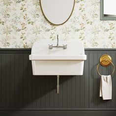 a white sink sitting under a bathroom mirror next to a wall mounted faucet