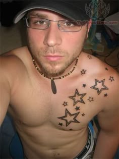 a shirtless man with stars on his chest wearing glasses and a baseball cap is looking at the camera