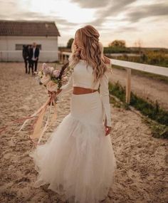 a woman in a wedding dress walking on the beach