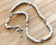 "* 6mm small Wood beads * St. Benedict crucifix * Blessed Mother & Sacred Heart medals * Strong white rosary cord * Ships free is ready-to-gift jewelry box * Free returns/exchanges Beautiful, petite rosary with white wooden beads, St. Benedict Crucifix, and both Miraculous and Sacred Heart medals. A perfect, thoughtful gift for First Communions, Confirmations, and Baptisms. MORE OPTIONS IN OUR SHOP! Not exactly what you're looking for? We've got some other great items! We welcome you to expl Adjustable White Rosary With Miraculous Medal, White Rosary With Wooden Beads As Gift, White Cross Rosary For Jewelry Making, White Wooden Beads Rosary As Gift, White Rosary With 8mm Beads Crucifix, White Rosary, St Benedict, Catholic Rosary, Rosary Catholic